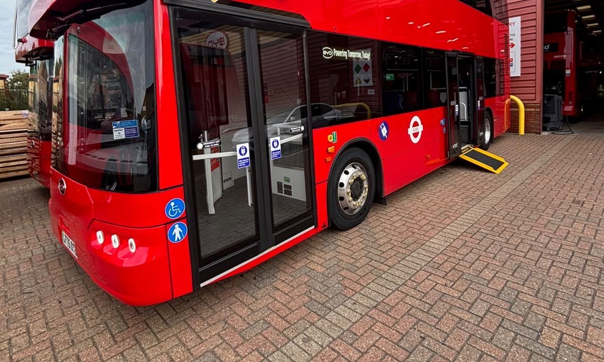 Front three-quarter view of a new London electric double-decker with a Compak ramp extended at the center door