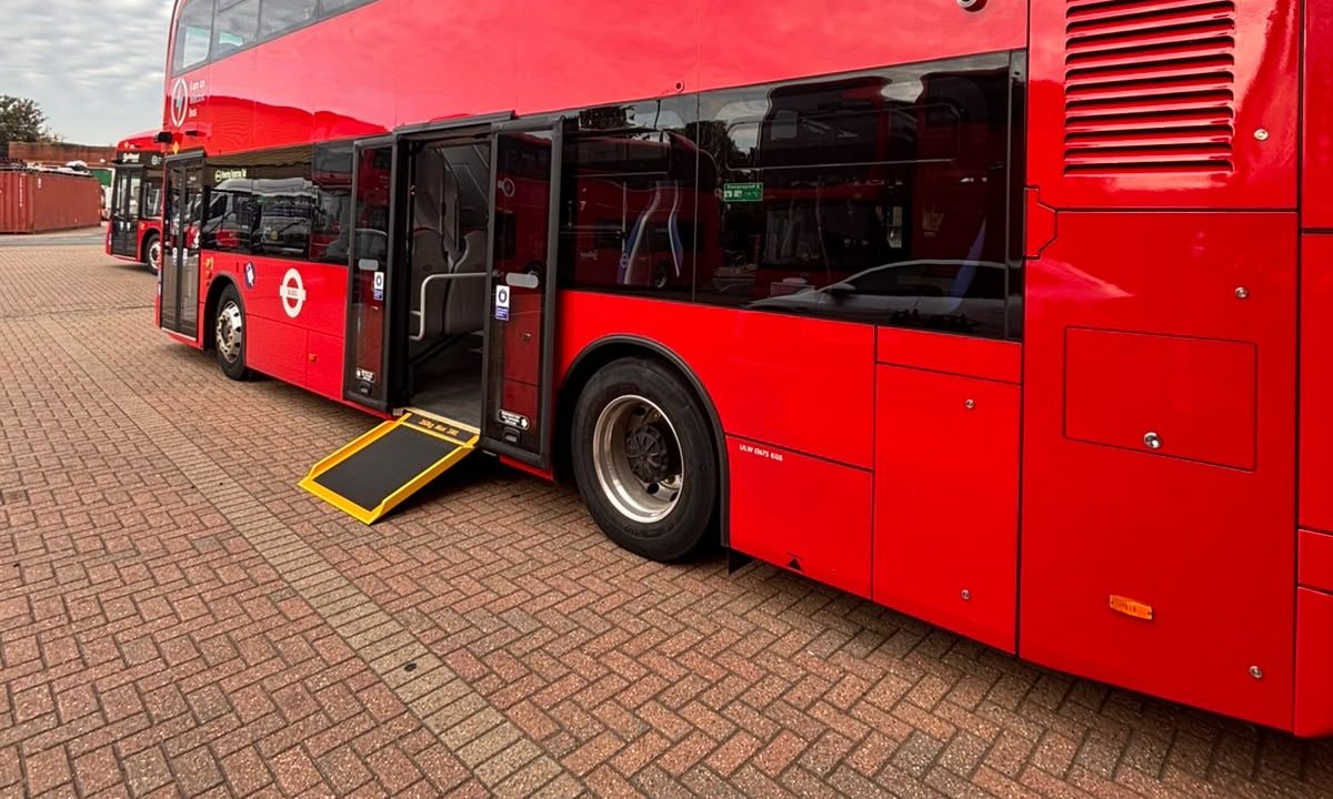 Side view of a new London electric double-decker with the Compak ramp lowered to the pavement